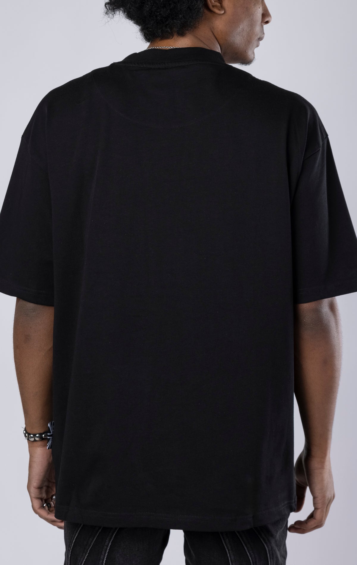 Blessed Darkness Boxy Tee. Black t-shirt made from 100% heavy black 250gr cotton. Features a boxy fit, dropped shoulders, longer sleeves, a 3D embroidered front message, and subtle "blessed" branding